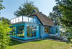 Außenansicht eines blauen Ferienhauses mit Garten - Haus Traudi - Top-Hundeurlaub