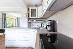 Moderne Küche mit Kochfeld und Holzregalen - Haus Traudi - Top-Hundeurlaub