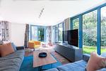 Heller Wohnbereich mit Sofa und Fernseher - Haus Traudi - Top-Hundeurlaub