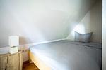 Schlafzimmer mit schrägen Wänden und Bett - Haus Traudi - Top-Hundeurlaub