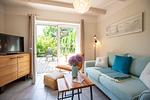 Helles Wohnzimmer mit Sofa und Blick auf den Garten - Sonnenwieck 02 - Top-Hundeurlaub