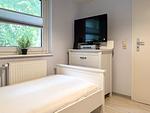 1. Schlafzimmer mit Kommode und TV - Haus 32c - Top-Hundeurlaub