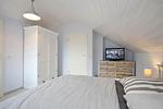 zweites Schlafzimmer mit Doppelbett, Kleiderschrank, Kommode und TV - Haus 32c - Top-Hundeurlaub