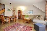Wohnzimmer mit Schlafcouch, Hocker und Essbereich - Wohnung 03-8 - Top-Hundeurlaub