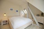 erstes Schlafzimmer mit Doppelbett und Komode - Wohnung 06 - Top-Hundeurlaub