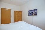 Schlafzimmer mit Doppelbett und TV - Wohnung 03 - Top-Hundeurlaub