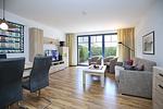 Wohnzimmer mit Schlafcouch, TV und Blick zur Terrasse - Wohnung 05-3 - Top-Hundeurlaub
