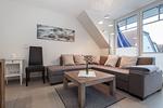 Wohnzimmer mit Sofaecke und Stuhl - Wohnung 05-8 - Top-Hundeurlaub