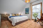 Schlafzimmer mit Doppelbett, Babybett und TV - Doppelhaushälfte 9a - Leuchtturm - Top-Hundeurlaub