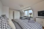 Nautic Lounge – Sea View: Schlafzimmer mit Meerblick, TV und gemütlicher Sitzecke. - Nautic Lounge - Sea View - Top-Hundeurlaub