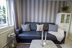 Gemütliches Sofa im maritimen Stil der Nautic Lounge – Beach House 1 mit Blick auf die Fensterfront. - Nautic Lounge  - Beach House 1 - Top-Hundeurlaub
