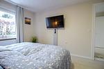 Schlafzimmer der Nautic Lounge – Beach House 1 mit Fenster, Smart-TV und gemütlicher Bettwäsche. - Nautic Lounge  - Beach House 1 - Top-Hundeurlaub