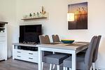 Wohn-/Essbereich mit Sitzgelegenheit und TV - Aparthotel Ostseeallee 4-30 - Top-Hundeurlaub