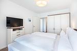Schlafzimmer mit Doppelbett, Kleiderschrank und TV - Aparthotel Ostseeallee 4-34 - Top-Hundeurlaub