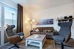 Wohn-/Essbereich mit Doppelschlafcouch, Couchtisch und Sessel - Aparthotel Ostseeallee 4-35 - Top-Hundeurlaub