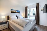 Schlafzimmer mit Boxspringbett (1,80 x 2,00 m) und TV - Aparthotel Ostseeallee 4-35 - Top-Hundeurlaub