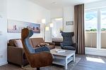 Wohn-/Essbereich mit Doppelschlafcouch, Couchtisch, Sessel und Zugang zur Dachterrasse - Aparthotel Ostseeallee 4-38 - Top-Hundeurlaub