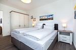 Schlafzimmer mit Boxspringbett und Kleiderschrank - Aparthotel Ostseeallee 4-38 - Top-Hundeurlaub