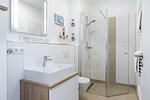 Badezimmer mit Dusche, Waschtisch, Spiegel und WC - Aparthotel Ostseeallee 4-38 - Top-Hundeurlaub