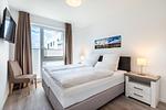 Schlafzimmer "1" mit Boxspringbett und TV - Aparthotel Ostseeallee 5-41 - Top-Hundeurlaub