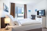 Schlafzimmer "2" mit Boxspringbett und TV - Aparthotel Ostseeallee 5-41 - Top-Hundeurlaub