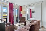 Wohnbereich mit Sofa, Sessel, Couchtisch mit Zugang zum Balkon - Resort Deichgraf 27-14 - Top-Hundeurlaub