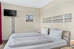 Schlafzimmer mit Doppelbett und TV - Resort Deichgraf 27-14 - Top-Hundeurlaub
