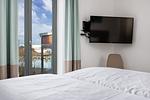 Schlafzimmer mit Doppelbett, TV und Zugang zum Balkon - Ohlerich Speicher 2-13 - Top-Hundeurlaub