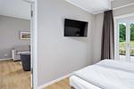 Schlafzimmer mit Doppelbett und Flatscreen TV - Strandresidenzen Binz-Prora D0.3 - Top-Hundeurlaub