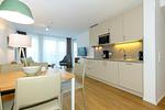 Wohn-Essbereich mit Couch, Couchtisch, Sessel und TV - Apartmentvilla Anna See 1-14 - Top-Hundeurlaub