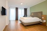 Schlafzimmer mit Doppelbett und TV - Apartmentvilla Anna See 1-14 - Top-Hundeurlaub