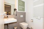 Badezimmer mit WC, Waschtisch und Spiegel - Apartmentvilla Anna See 1-16 - Top-Hundeurlaub