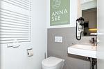 Badezimmer mit WC, Waschtisch und Spiegel - Apartmentvilla Anna See 1-18 - Top-Hundeurlaub