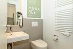 Badezimmer mit WC, Waschtisch und Spiegel - Apartmentvilla Anna See 2-06 - Top-Hundeurlaub