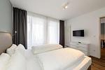 Schlafzimmer mit Doppelbett und TV - Deichhäuser Anna Küste 1-24 - Top-Hundeurlaub