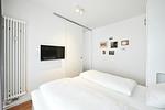 Schlafzimmer mit Doppelbett und Flatscreen TV - Deichhäuser Anna Küste 3-13 - Top-Hundeurlaub