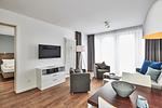 Wohn-Essbereich mit Couch, Flatscreen TV, Esstisch, Sitzgelegenheit und Zugang zum Balkon - Deichhäuser Anna Küste 4-34 - Top-Hundeurlaub
