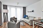 Wohn-Essbereich mit Couch, Sessel, Esstisch und Zugang zum Balkon - Deichhäuser Anna Küste 4-34 - Top-Hundeurlaub