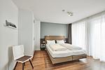 Schlafzimmer mit Doppelbett, Kleiderschrank und Zugang zum Balkon - Deichhäuser Anna Küste 4-34 - Top-Hundeurlaub
