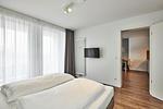 Schlafzimmer mit Doppelbett, Kleiderschrank und Zugang zum Balkon - Deichhäuser Anna Küste 4-34 - Top-Hundeurlaub