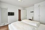 Schlafzimmer mit Doppelbett, Kleiderschrank und Flatscreen TV - Deichhäuser Anna Küste 4-34 - Top-Hundeurlaub