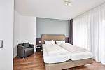 Schlafzimmer mit Doppelbett, Kleiderschrank, Flatscreen TV und Zugang zur Terrasse - Deichhäuser Anna Küste 4-14 - Top-Hundeurlaub
