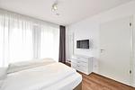 Schlafzimmer mit Doppelbett, Flatscreen-TV und Zugang zur Terrasse - Deichhäuser Anna Küste 4-14 - Top-Hundeurlaub