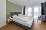 Schlafzimmer mit Doppelbett und Sitzgelegenheit - Deichhäuser Anna Küste 6-31 - Top-Hundeurlaub