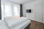 Schlafzimmer mit Doppelbett, Flatscreen-TV und Zugang zur Terrasse - Deichhäuser Anna Küste 7-14 - Top-Hundeurlaub