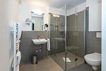 Badezimmer mit Dusche, Waschbecken, WC und Spiegel - Deichhäuser Anna Küste 7-14 - Top-Hundeurlaub