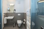 Badezimmer mit Dusche, Waschbecken und Spiegel - Deichhäuser Anna Küste 7-22 - Top-Hundeurlaub