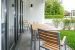 Überdachte Terrasse mit Sitzgelegenheit und Grünfläche - Deichhäuser Anna Küste 8-14 - Top-Hundeurlaub