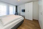 Schlafzimmer mit Doppelbett und Flatscreen TV - Deichhäuser Anna Küste 8-31 - Top-Hundeurlaub