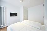 Schlafzimmer mit Doppelbett und Flatscreen TV - Deichhäuser Anna Küste 4-30 - Top-Hundeurlaub